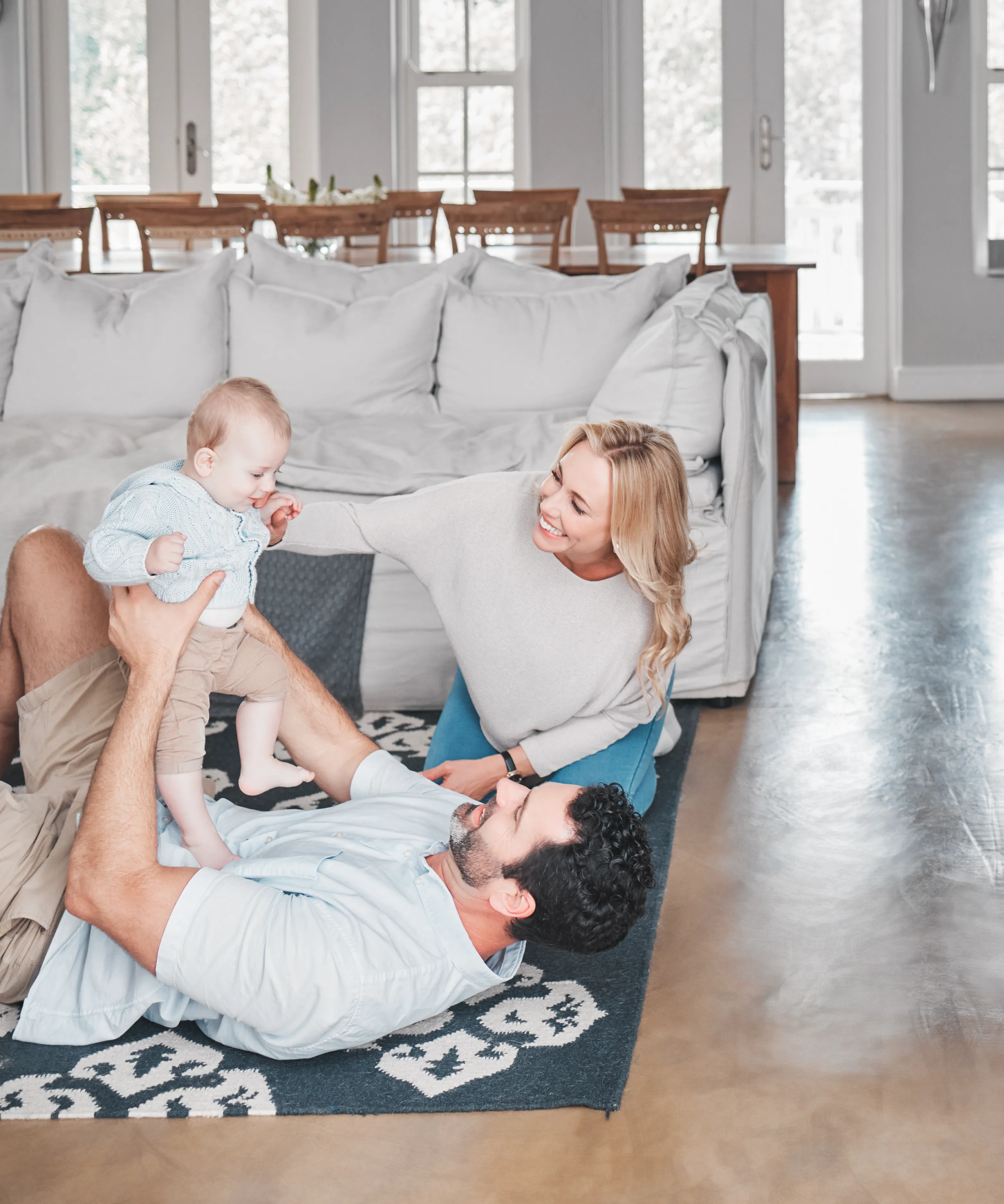 Parents playing with their baby together in a bright home.